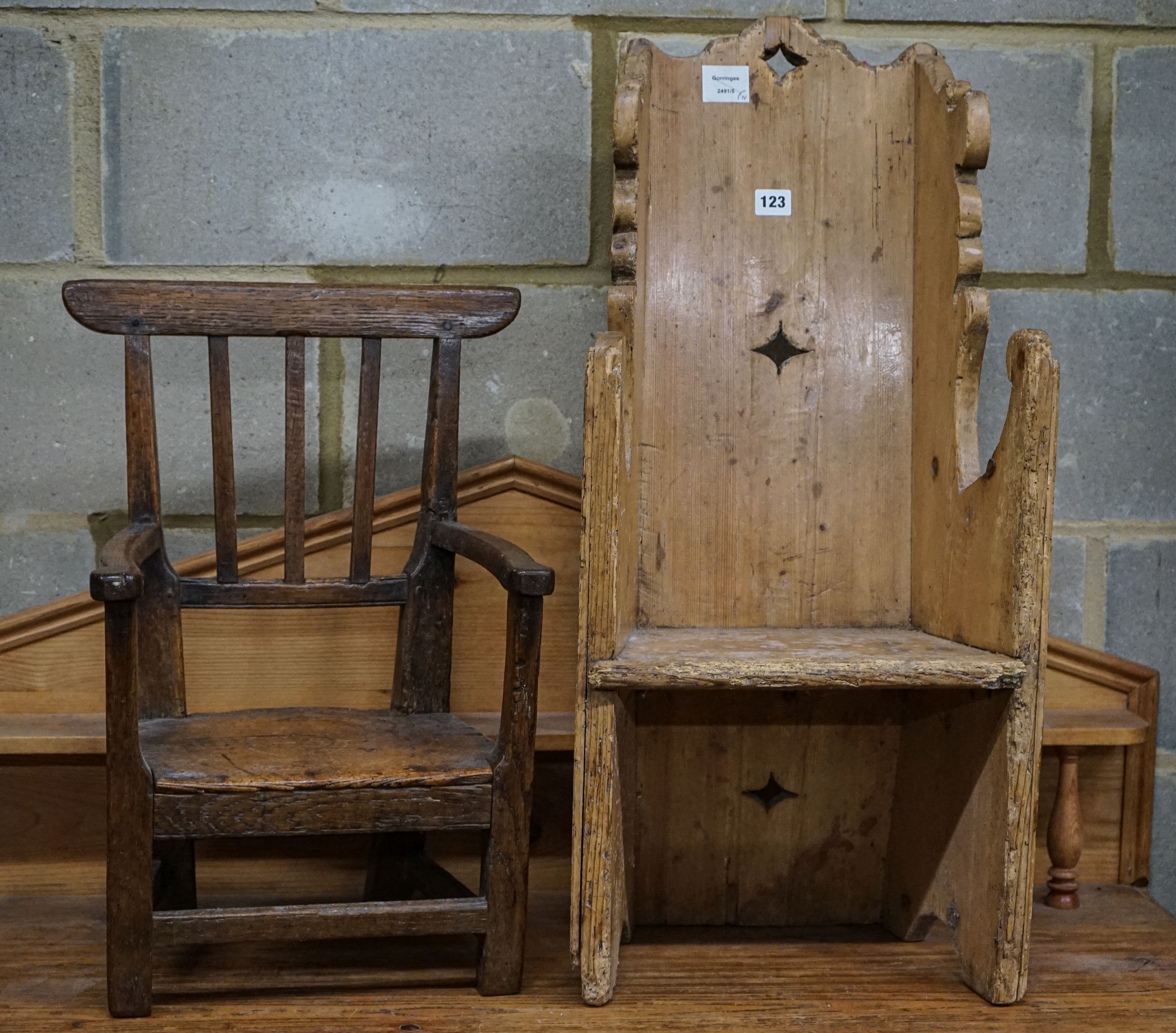 An early 19th century primitive oak child's chair with solid seat, width 39cm height 56cm and a carved pine child's chair, height 78cm